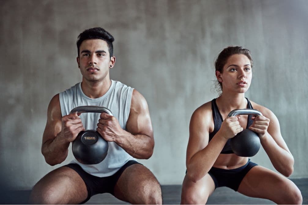 A couple lifting ball weights by the handle