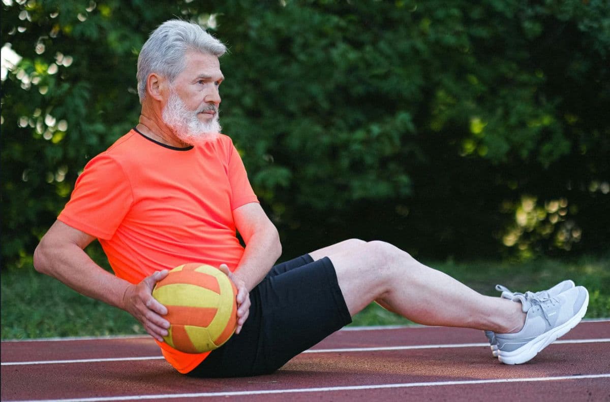An older man doing exercise with a ball