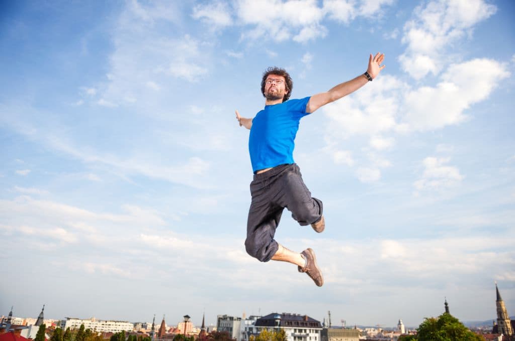 A man jumping in the sky with the city skyline below him